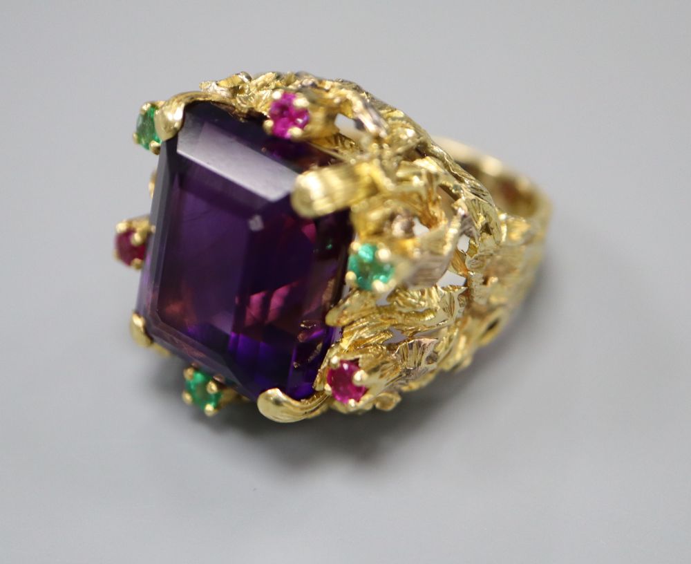 A yellow metal, amethyst, emerald and ruby cluster set naturalistic dress ring, size M, gross 20.9 grams.